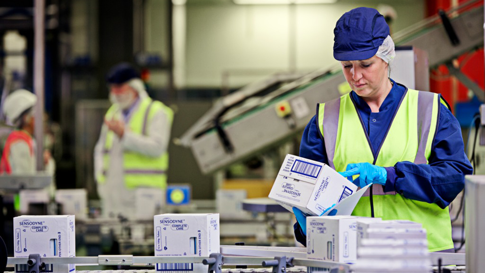 Siobhan Taub looking at a box of Sensodyne toothpaste on a production line, Maidenhead UK