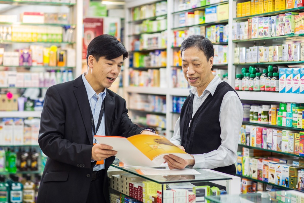 Ricky Wan sales rep discussing a brochure with a pharmacist