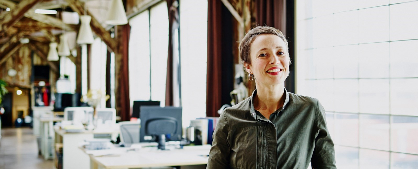 Woman in an office, smiling at the camera