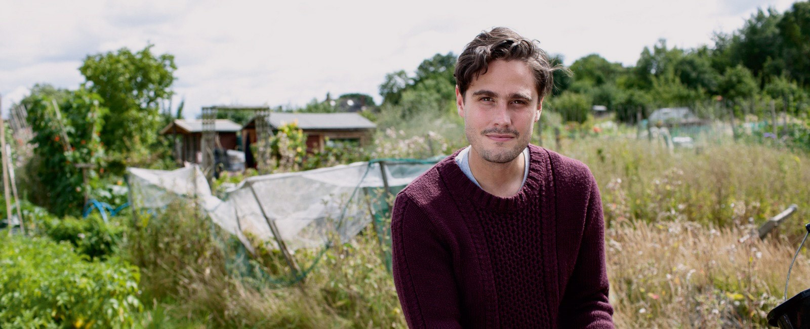 Man in the countryside, smiling at the camera